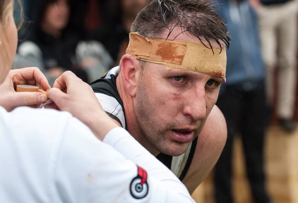 The Imperials trainer tapes up a cut above Adam Dehring's left eye. Photo: Jeremy Hedley.