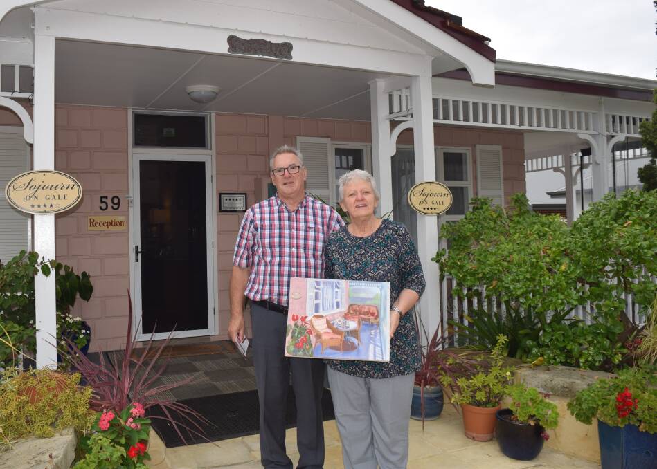 Sojourn on Gale owners Ivan and Ann Sandler with a painting given to them by a guest who stayed at their bed and breakfast.