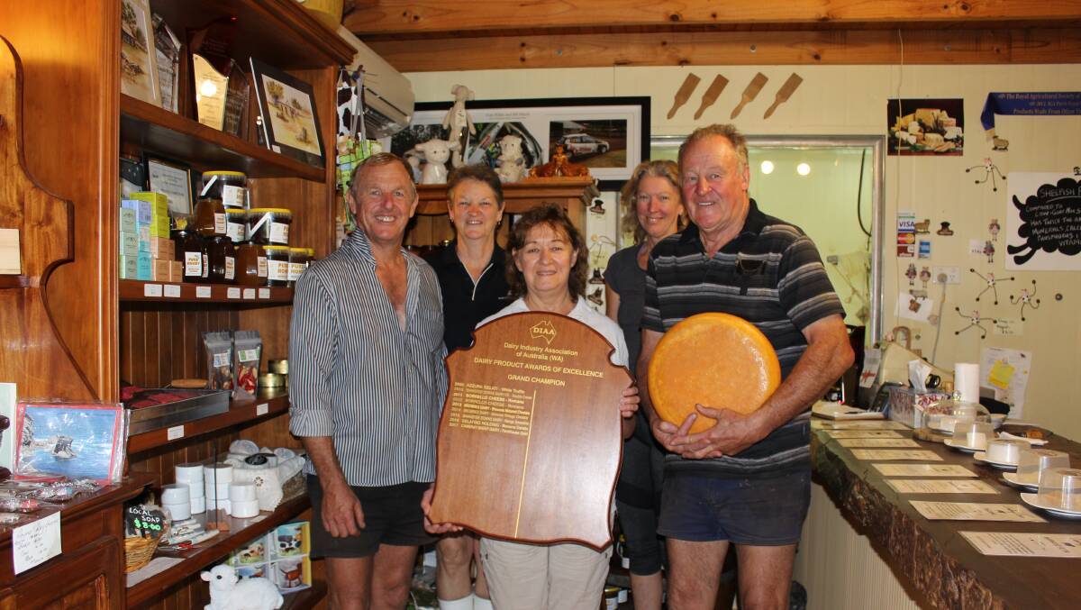 Dave and Robyn Robinson, employee Lauren Cartledge (back) with Jane and Bruce Wilde holding the Grand Champion Dairy Product award winner's shield and a cheese round in the shop at Cambray farm.