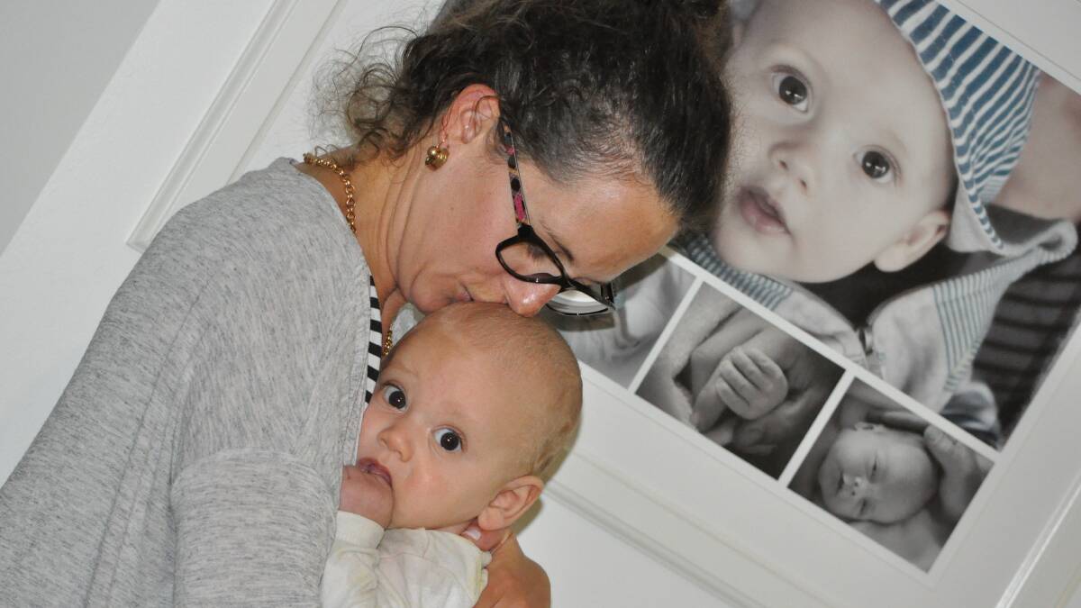 Healing hands: Lara-Jane with six-month-old Kobe. Photo: Kate Hedley.