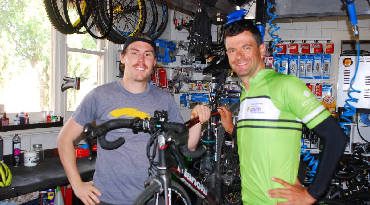 Fat Duck Cycles and Espresso bike mechanic Rex with Greg McDermott in the bike shop. McDermott is riding around Australia for Youth Off The Streets. Photo supplied.