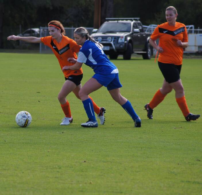 DEFENCE: Geographe Bay Seasider's Lauren Valli goes in for the kick while keeping off a Dunsborough player. The team won 5-2, securing their spot in the second half of the Premier League, a first time feat. Photo:Lily Yeang.