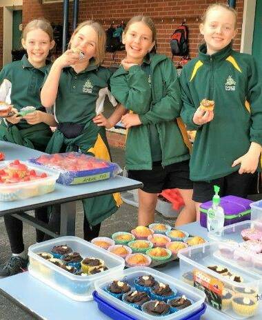 Emilie Costley (second left) with her school friends and fundraiser assistants Hannah, Daisy and Meg, who helped sell 300 cupcakes to hungry school students.