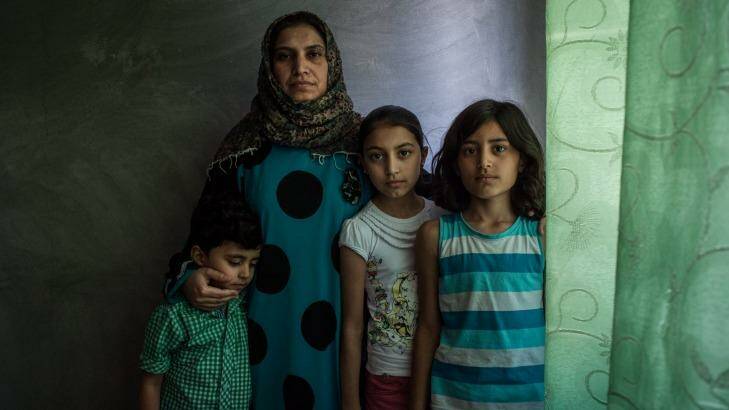 Basma poses for a portrait with her children Nour, Osama and Assadullah in the apartment her family now shares in Sanliurfa, Turkey. Photo: Alice Martins