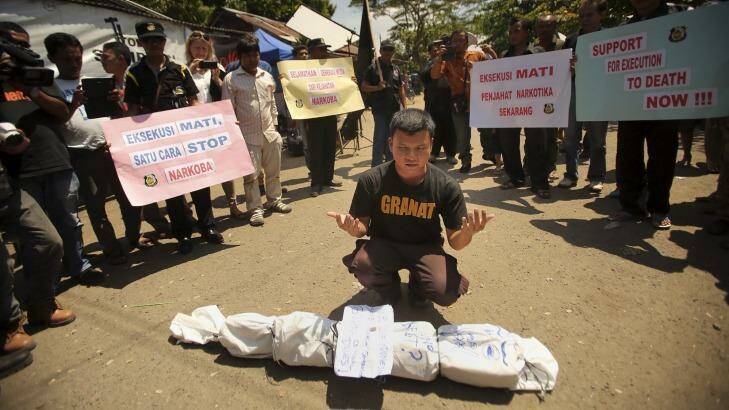 An anti-drugs protester in Cilacap prays in front of an effigy of a drug smuggler. Photo: Kate Geraghty