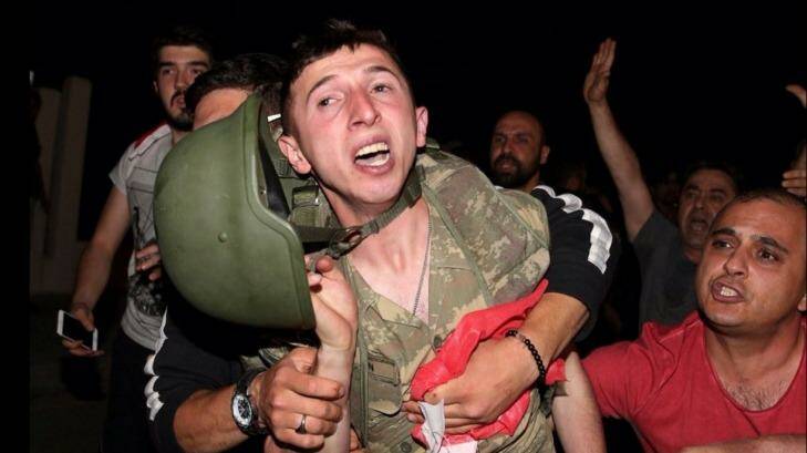 A Turkish soldier being held by members of the public.  Photo: Michael Schlechta