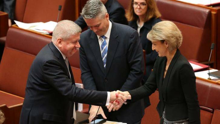 Employment minister Senator Michaelia Cash is congratulated by Communications Minister Mitch Fifield and Finance Minister Senator Mathias Cormann for the passing of the ABCC bill on Wednesday. Photo: Andrew Meares