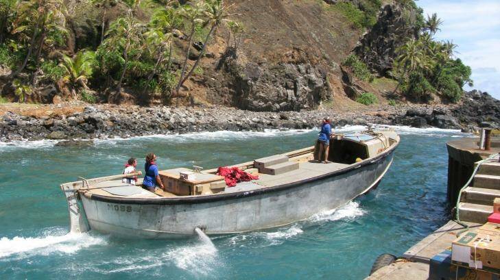Pitcairn Islanders launch a longboat from Bounty Bay to meet a supply ship anchored offshore. Photo: Craig Tansley