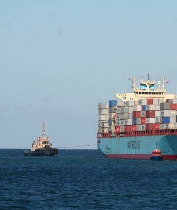 Tugs try to free the container ship Maersk Garonne after it ran aground in Fremantle Harbour. Photo: Brendan Foster