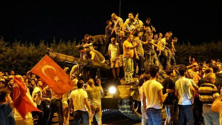 People gather on a Turkish army tank at Ataturk Airport in Istanbul. Photo: Defne Karadeniz