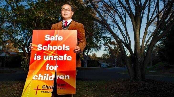 Rev. David Kim with one of the ACT Christian Democratic Party's anti safe schools campaign signs after it had been vandalised at his home. Photo: Sitthixay Ditthavong