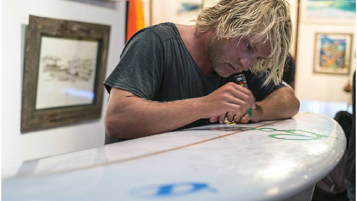 Artist Dave Alp decorates a surfboard at the second annual Foam Lust exhibition. Photo: Sandy Powell/Augusta-Margaret River Mail.