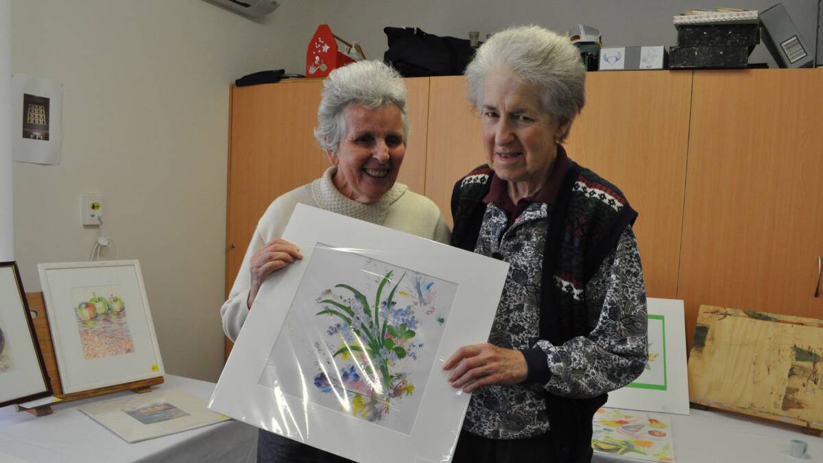 Capecare residents Merri Elizabeth and Penny Coulson with some of the resident’s artwork.