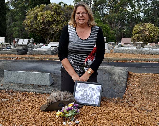 Desne Chapman sits at the head of the unmarked grave of her great grand-uncle in Bridgetown.