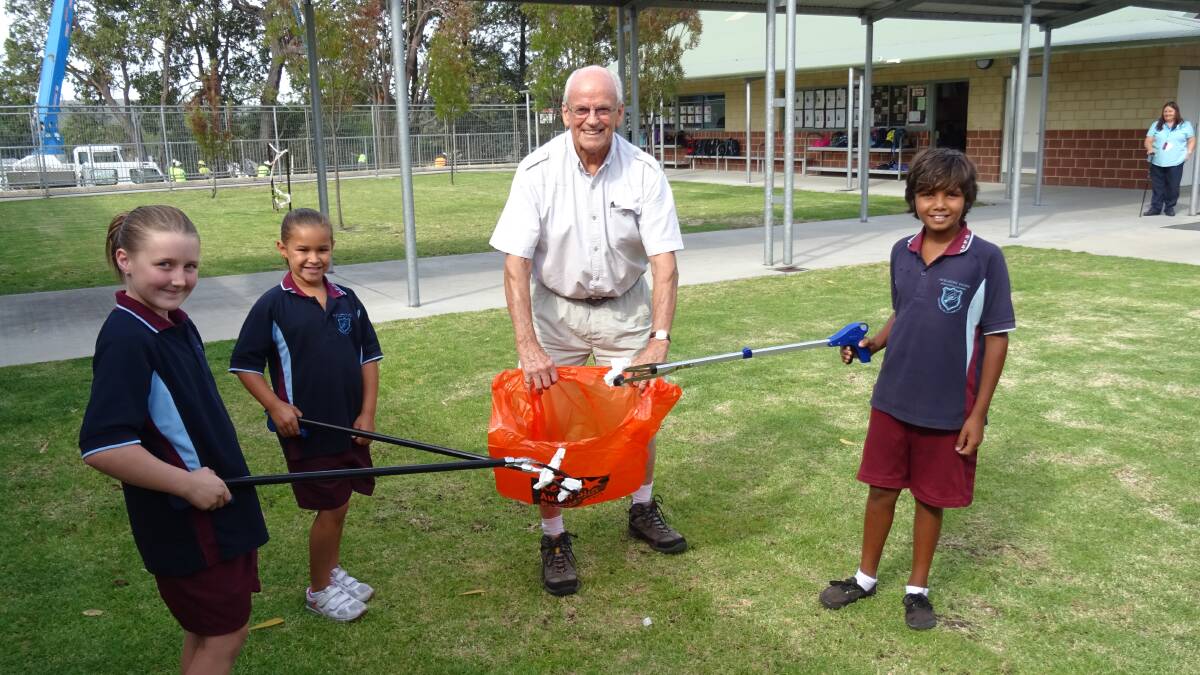 Test run: Rotary club president Bob Greig visited Wilson Park Primary School on Tuesday to promote the forthcoming roads clean up days. Skye
Washer (left), Amelia Hart-Ashley and Tyler Abraham put new litter pick-up sticks to the test. The sticks will be used by volunteers in the clean-up days
which start on the March 28 and 29 weekend.