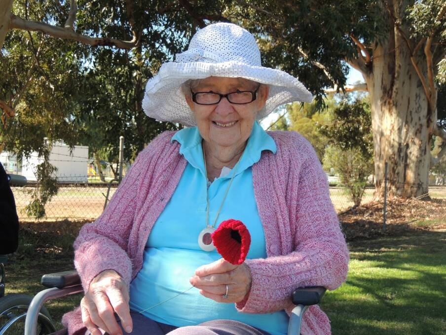 Beloved local matriarch, Nell Breeze, plants a poppy.