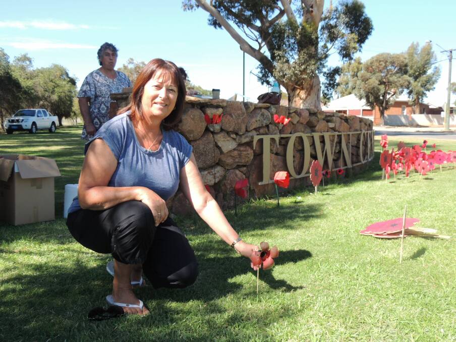Anita Venner from Orange, NSW, stops to plant a poppy.