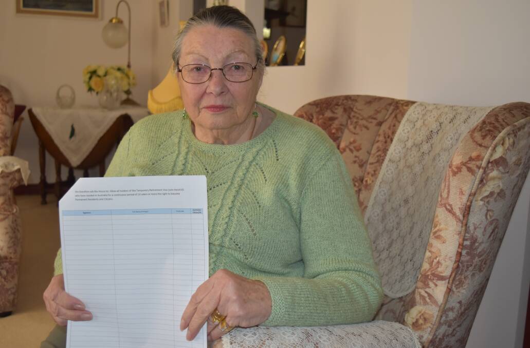 Eve Crompton-Couvela holds a petition seeking to become a permanent resident. 
