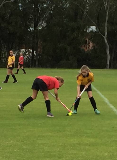 A Mackillop and Capel player battle it out for possession of the ball.