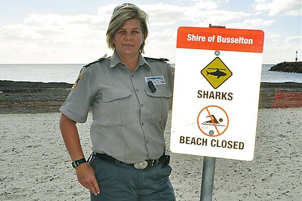 City ranger Michelle McGee with one of the signs after a shark sighting at Port Geographe last week.