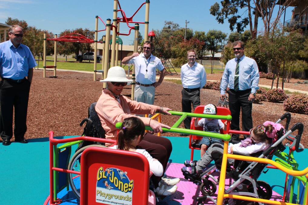 Olivia and Nash Pursell enjoy the new playground with Claire Monk and Hilary Rumley from the disability committee. 