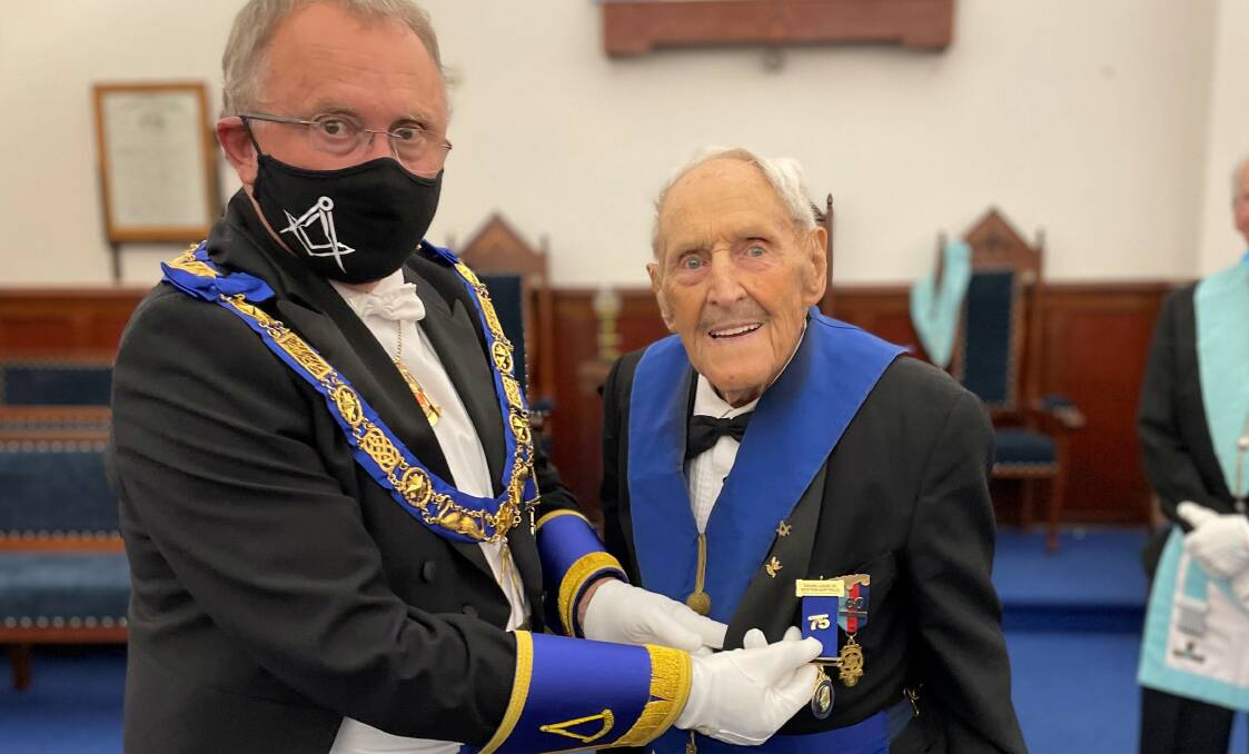 75 years: Immediate Past Grand Master Worshipful Brother Peter Kirwan presents the 75th Freemasons jewel to Right Worshipful Brother Keith MacKinnon. Picture: Supplied.