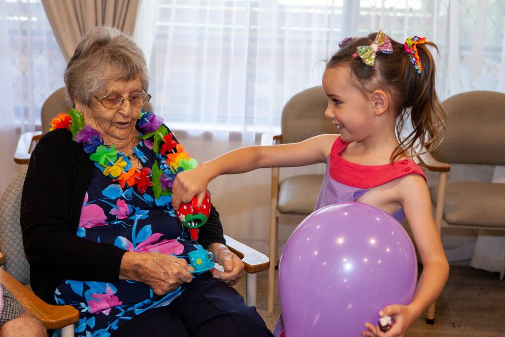 Five-year-old Eulsie Gacia pours 89-year-old resident Marj Watterson a cup of tea. Photo: Supplied.