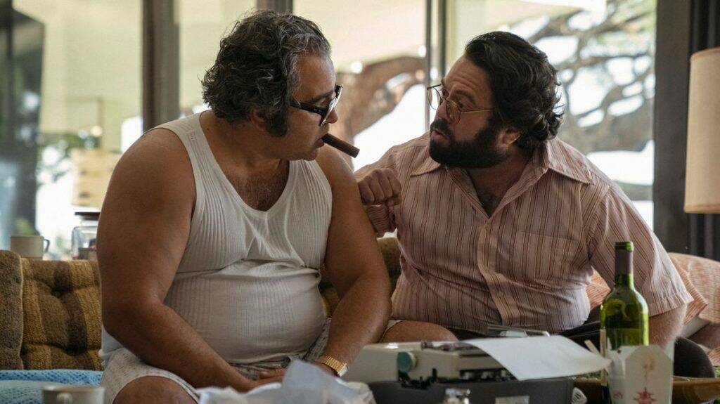 Patrick Gallo (Mario Puzo) and Francis Ford Coppola (Dan Fogler) become affectionate, bickering housemates as they work on the script.