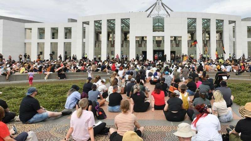 Women protested in Canberra by surrounding Parliament House. 