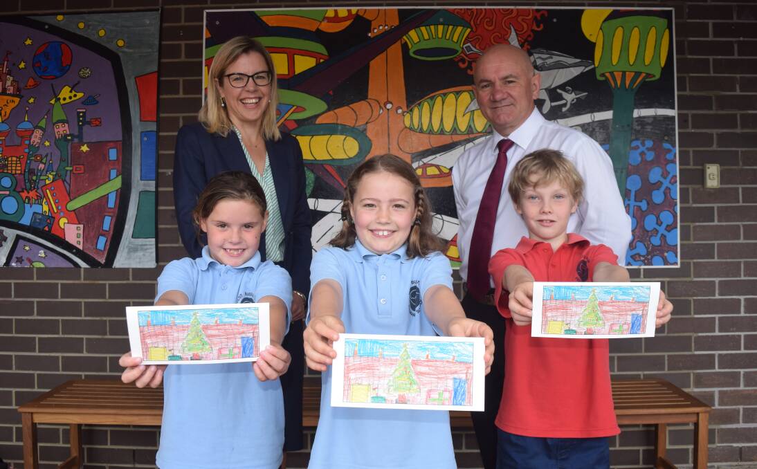 Vasse MP Libby Mettam and West Busselton Primary School principal Jamie Adair with Indigo Hoffman, Indi Dowling and Isaac Bilsby, who hold Indi's winning design. Image Sophie Elliott.