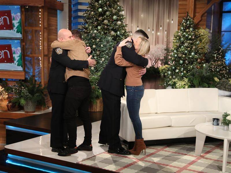 John Drennan and Daniella Anthony hug the two NYPD officers who returned their ring.