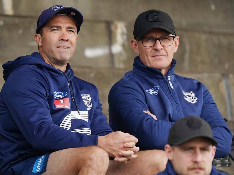 Geelong Chris Scott (l) is among the AFL coaches set to take a hefty pay cut this season.