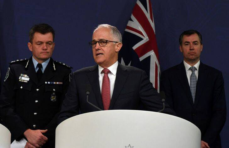 Australian Prime Minister Malcolm Turnbull speaks during an address to media alongside AFP Commissioner Andrew Colvin (left) and Minister for Justice Michael Keenan (right) at the Commonwealth Parliamentary Offices, Sydney, Sunday, July 30, 2017 following yesterdays counter terror raids. Four men have been arrested after the NSW Joint Counter Terrorism team conducted raids throughout Sydney suburbs. (AAP Image/Sam Mooy) NO ARCHIVING