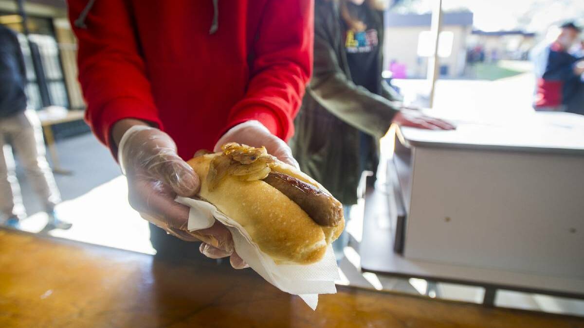 The sausage on a bread roll served to voters at polling stations has become a modern Australian tradition on election day. Picture: Dion Georgopoulos