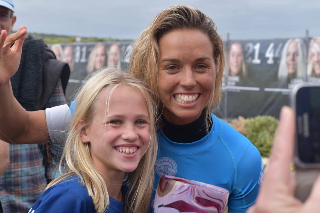 A young fan sneaks a chance to grab a photo with champ Sally Fitzgibbons at the Margaret River Pro.