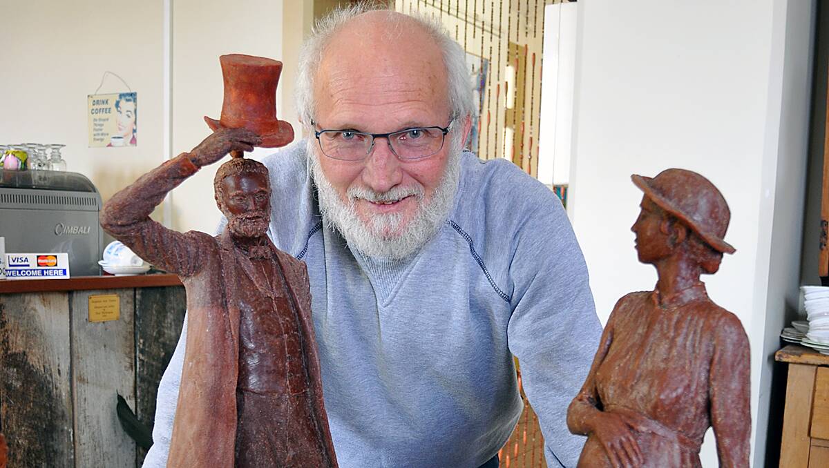 Sculptor Greg James with miniatures of his statues.